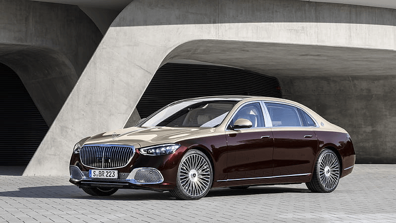 Professional chauffeur standing in front of luxury vehicle at airport